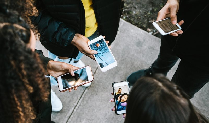 Inclusive opportunities through digital Young people on phones in a circle