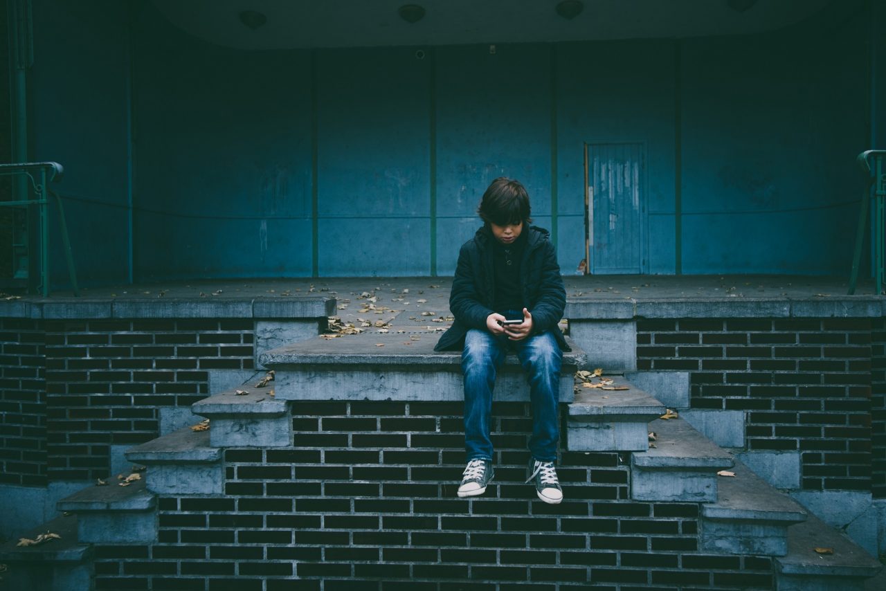 Using digital to help young peoples’ mental health young boy holding mobile phone