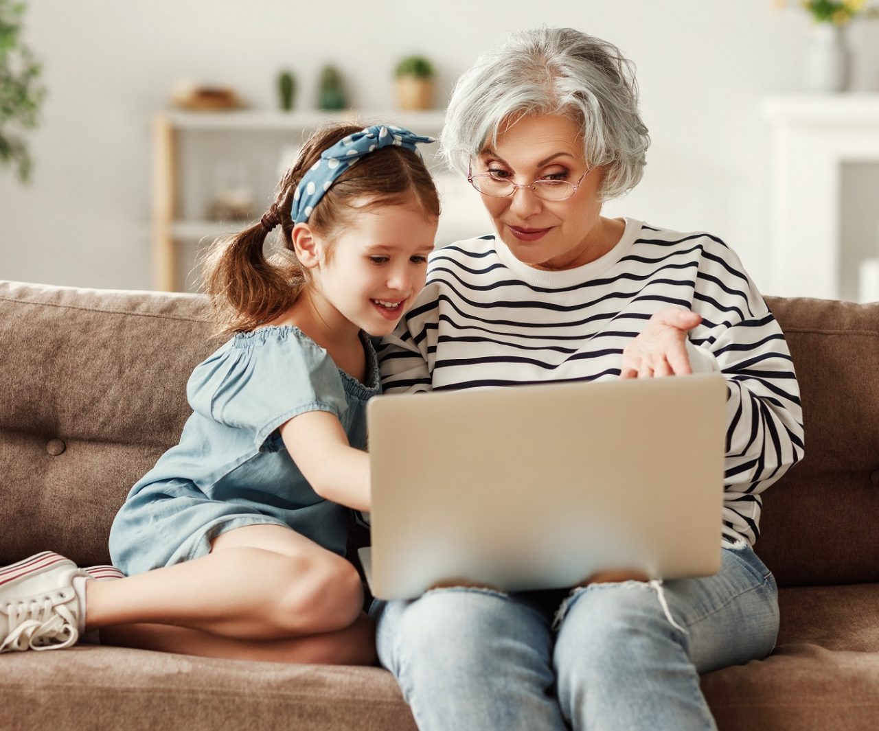 Little child girl with grandmother using laptop at home Little child girl with grandmother using laptop at home